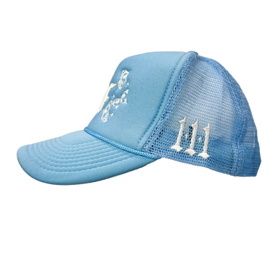 Close up image of side of blue trucker hat with white font