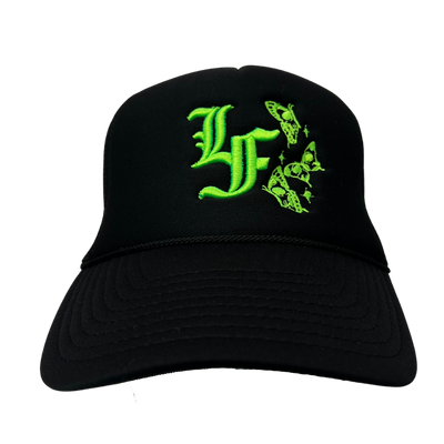 Close up image of the front of black trucker hat with green font